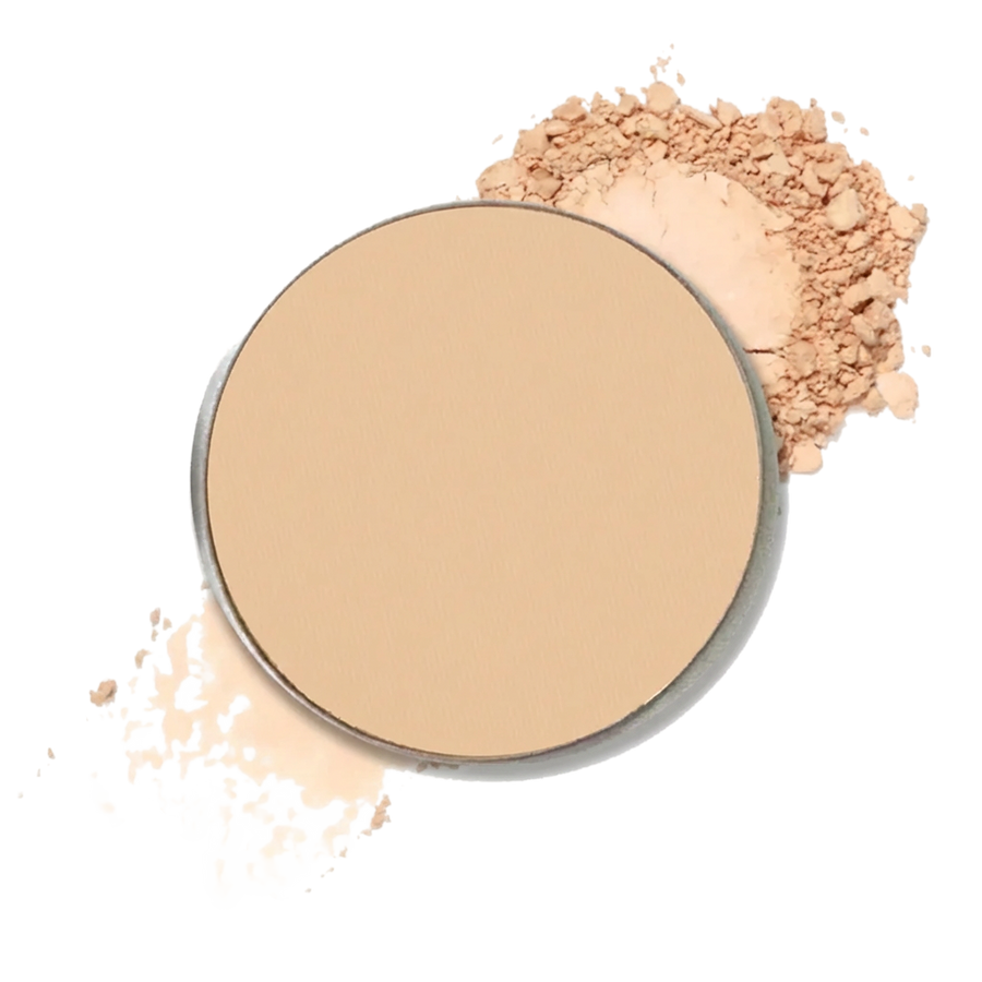A round makeup compact filler filled with light beige powder, shown with loose powder scattered around it.